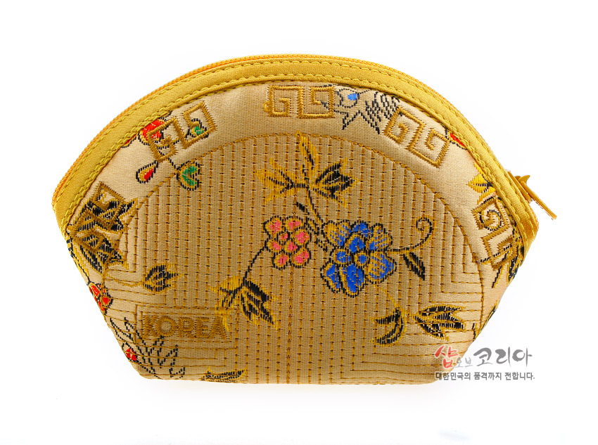 [텍스트: KOREA, 샵오브코리아 대한민국의 품격까지 전합니다.] 금색 비단 누비 소재의 반달형 동전지갑, 태극·연속문과 꽃·잎사귀 자수 장식 구성