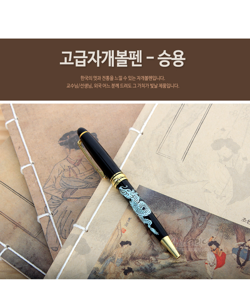 [텍스트: 고급자개볼펜 - 승용 / 한국의 멋과 전통을 느낄 수 있는 자개볼펜입니다. 교수님/선생님, 외국 어느 분께 드려도 그 가치가 빛날 제품입니다.] 검은 옻칠 바탕에 청록색 자개 상감 승용용 문양과 금색 금속 장식이 조화를 이룬 볼펜 이미지 설명