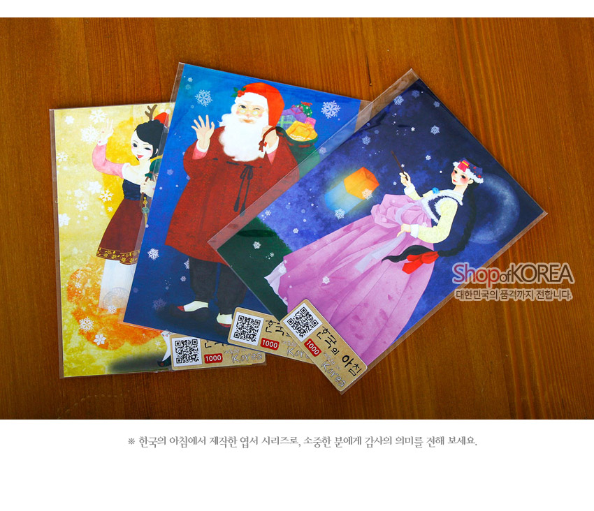 [텍스트: Shop of KOREA, 한국의 아침, 1000] 한복 입은 산타걸과 산타, 눈꽃 문양을 노랑·파랑·보라 색조로 표현한 일러스트 엽서 세트 이미지