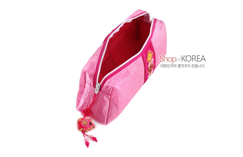 [텍스트: Shop of KOREA 대한민국의 품격까지 전합니다.] 분홍색 누비 비단 소재, 지퍼에 복자 자수 복돼지 매듭장식이 달린 직사각형 필통형 파우치 디자인