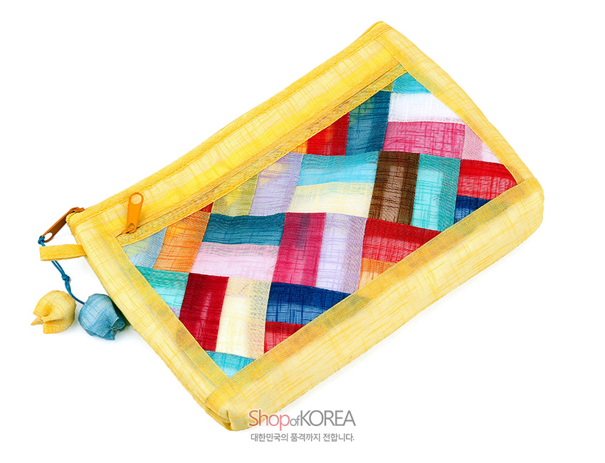 [텍스트: Shop of KOREA 대한민국의 품격까지 전합니다.] 노란 모시 바탕 위 다채로운 색상의 조각보 누비 기법이 돋보이는 파우치, 매듭 장식 술 지퍼 포인트 디자인