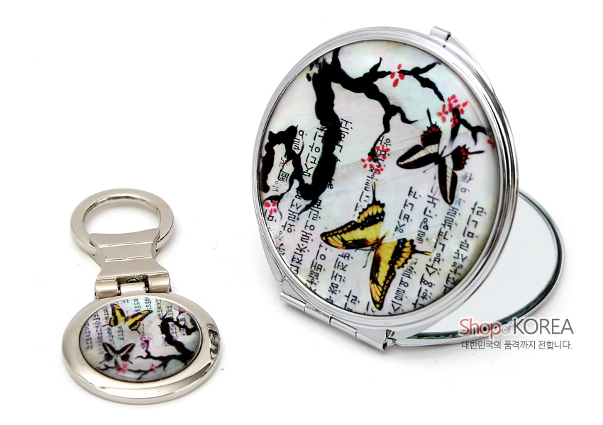[텍스트: Shop OF KOREA 대한민국의 품격까지 전합니다.] 자개 바탕 위 옻칠 기법, 한글 서체와 매화나비 문양이 어우러진 은색 금속 손거울·열쇠고리 세트 디자인