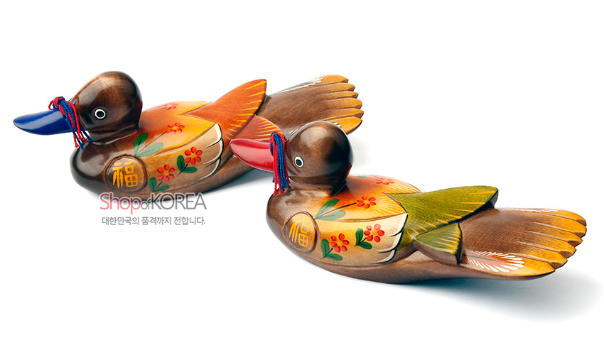 [텍스트: ShopofKOREA, 대한민국의 품격까지 전합니다.] 나무 재질에 채색 기법으로 표현된 꽃과 복(福) 문자 문양, 붉은·푸른 부리와 꼬리의 원색 대비가 돋보이는 원앙 한 쌍 목각 장식