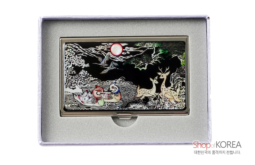 [텍스트: Shop of KOREA 대한민국의 품격까지 전합니다.] 흑색 바탕 금속 위 자개 상감 기법, 원앙·사슴·소나무와 붉은 해를 오색 자개빛으로 섬세하게 표현한 장생 문양 명함집 디자인
