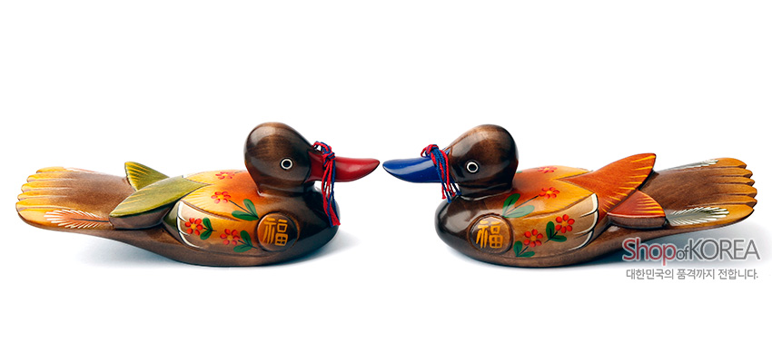 [텍스트: Shop of KOREA / 대한민국의 품격까지 전합니다.] 나무 재질에 채색 기법을 활용한 원앙 한 쌍 목각 장식, 붉은·푸른 머리와 꽃무늬·복(福)자 문양, 색실 매듭 장식이 돋보이는 전통 공예품