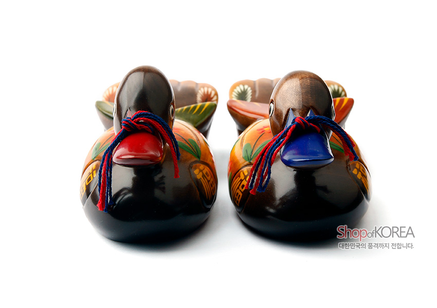 [텍스트: Shop of KOREA 대한민국의 품격까지 전합니다.] 칠한 나무 재질 위에 꽃과 복(福) 문자 문양을 채색하고 붉은색·푸른색 머리와 색실 끈으로 장식한 원앙 한 쌍 목각 장식품