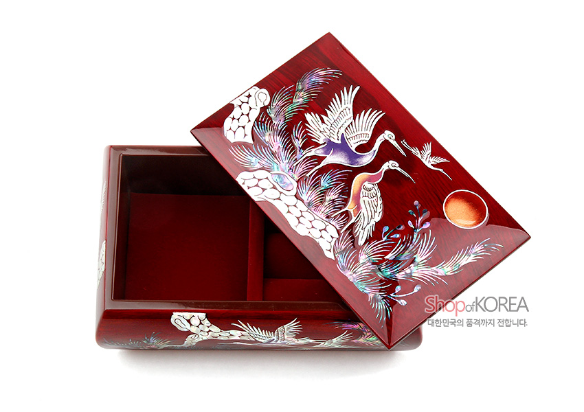 [텍스트: Shop of KOREA 대한민국의 품격까지 전합니다.] 붉은 옻칠 바탕 위 자개 상감 기법으로 송학과 소나무, 해를 그린 직사각 반지꽂이 다용도함