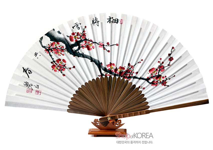 [텍스트: ShopofKOREA 대한민국의 품격까지 전합니다.] 흰 종이 위 수묵채색 매화 가지와 붉은 매화꽃 문양, 갈색 대나무 살과 금색 장식 매듭이 어우러진 전통 접이식 오죽선 모습