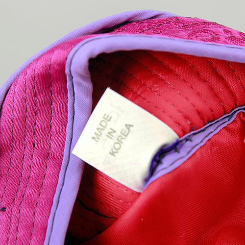 [텍스트: MADE IN KOREA] 분홍색과 보라색 비단 느낌 원단에 세로 누비선이 보이는 안감 클로즈업 이미지