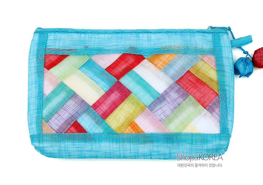 [텍스트: Shop of KOREA 대한민국의 품격까지 전합니다.] 청색 모시 바탕 위 다채로운 색상의 조각보 누비 기법이 사선 격자 형태로 배치된 파우치와 옆면 실크 매듭 장식 구성