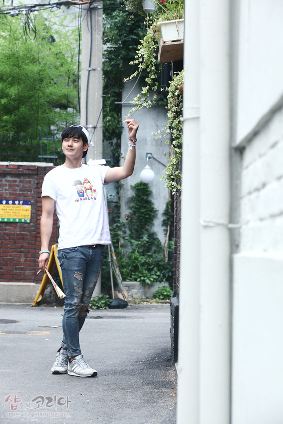 [텍스트: WE KOREA] 한복 입은 신랑신부 캐릭터와 태극·전통문양이 알록달록 입체발포로 인쇄된 흰색 반소매 티셔츠 연출 컷