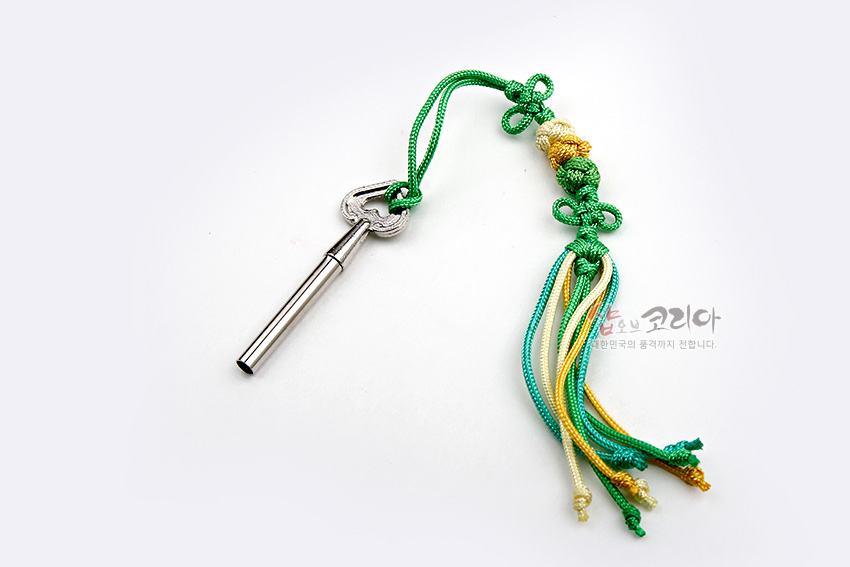 [텍스트: 샵오브코리아 대한민국의 품격까지 전합니다.] 금속 열쇠와 연결된 초록·노랑 색실 전통 매듭 장식, 유려한 술 장식 구성