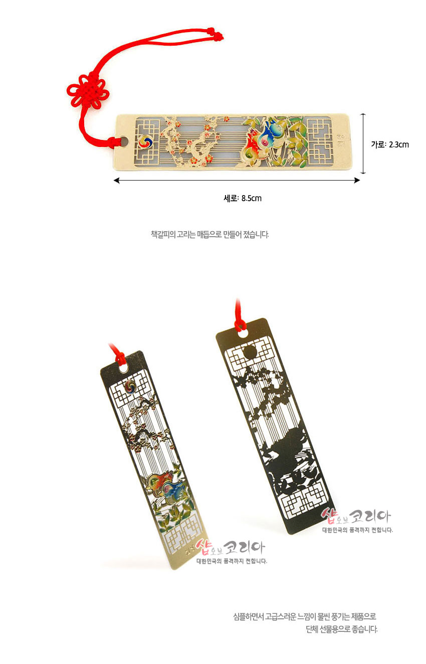 [텍스트: 세로: 8.5cm, 가로: 2.3cm, 책갈피의 고리는 매듭으로 만들어 졌습니다.] 금속 재질 위 금장과 칠보 기법, 원앙·매화·태극 문양, 붉은 전통 매듭 끈 장식 책갈피 디자인