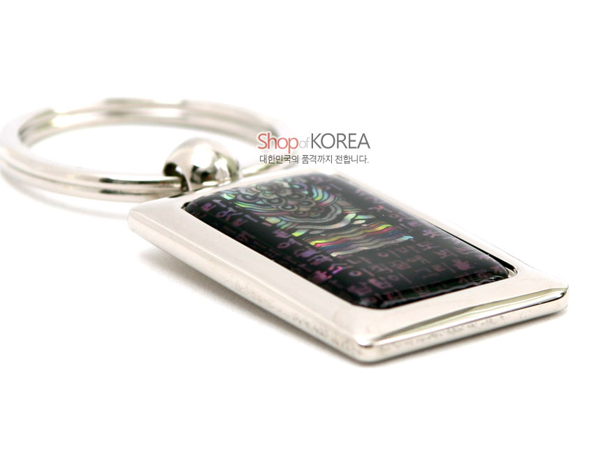 [텍스트: Shop of KOREA 대한민국의 품격까지 전합니다.] 은색 금속 사각 테두리 안 자개 상감 기법으로 시조 한글과 단청 문양을 채색한 열쇠고리 디자인