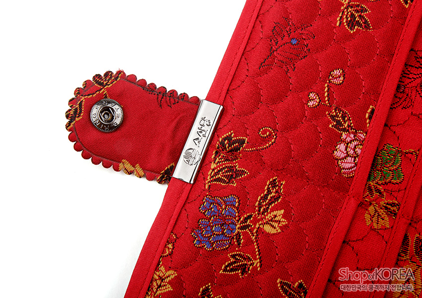 [텍스트: ANB, ShopofKOREA 대한민국의 공예가치 전달합니다] 붉은 비단 누비 바탕에 꽃과 잎사귀 전통 문양 자수, 금속 장식과 스냅 단추가 조화된 장지갑 디테일 이미지