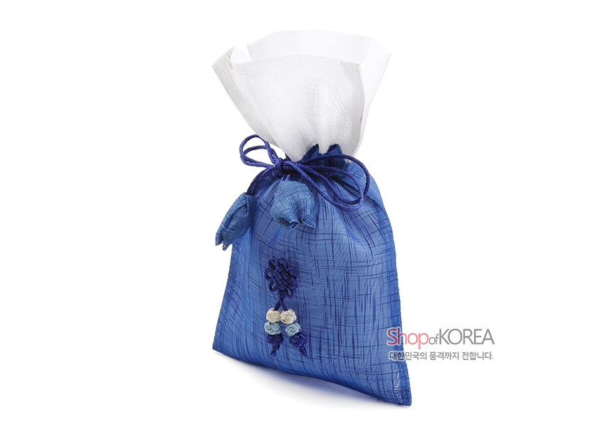 [텍스트: Shop of KOREA 대한민국의 품격까지 전합니다.] 청색 모시 원단과 흰색 모시 상단 대비, 전통 매듭과 조개 모양 장식 더한 복주머니형 매듭 주머니 모습