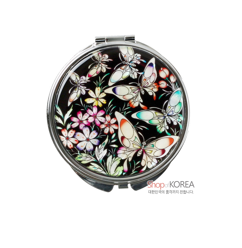 [텍스트: Shop of KOREA 대한민국의 품격까지 전합니다.] 검은 바탕 위 자개 상감 기법으로 다채로운 나비와 꽃 문양을 섬세하게 장식한 원형 금속 손거울 디자인