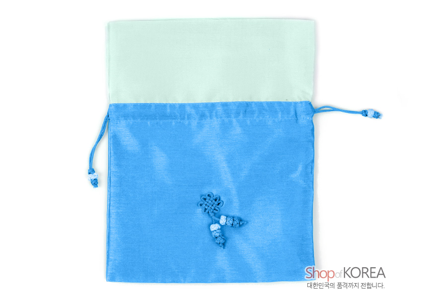 [텍스트: Shop of KOREA 대한민국의 품격까지 전합니다.] 청색 비단과 옅은 민트색 천의 배색 매듭주머니, 중앙 전통 매듭과 구슬 매듭술 장식, 양측 끈 조임 구조의 공예품