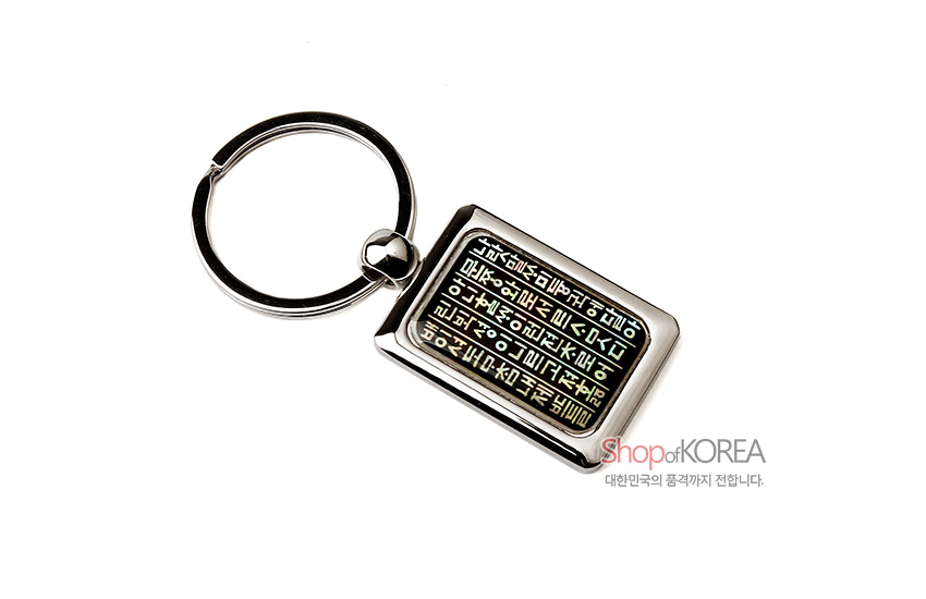 [텍스트: Shop of KOREA 대한민국의 품격까지 전합니다.] 금속 테두리 안에 자개 상감 기법으로 훈민정음 글귀를 세로 배열한 사각형 열쇠고리 디자인