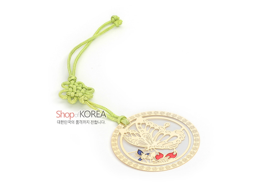 [텍스트: Shop of KOREA / 대한민국의 품격까지 전합니다.] 금장 도금 원형 금속 틀 안 나비 문양 투각 기법 장식, 청색·홍색 포인트 채색과 연두색 전통 매듭 끈 구성