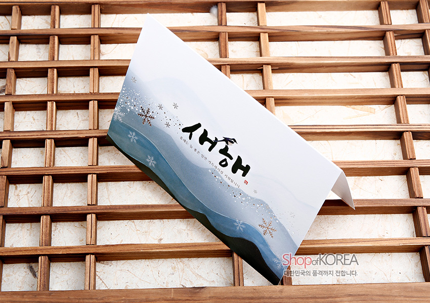 [텍스트: 새해] 청록·회색 수묵 산수 그러데이션과 은빛 눈꽃 문양이 어우러진 가로형 전통 종이 연하장 디자인