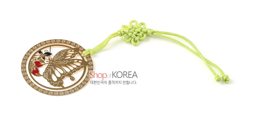 [텍스트: Shop of KOREA, 대한민국의 품격까지 전합니다.] 금장 금속으로 제작된 원형 테두리와 나비 문양 책갈피, 적색·청색 채색 포인트와 연두색 전통 매듭 끈 장식