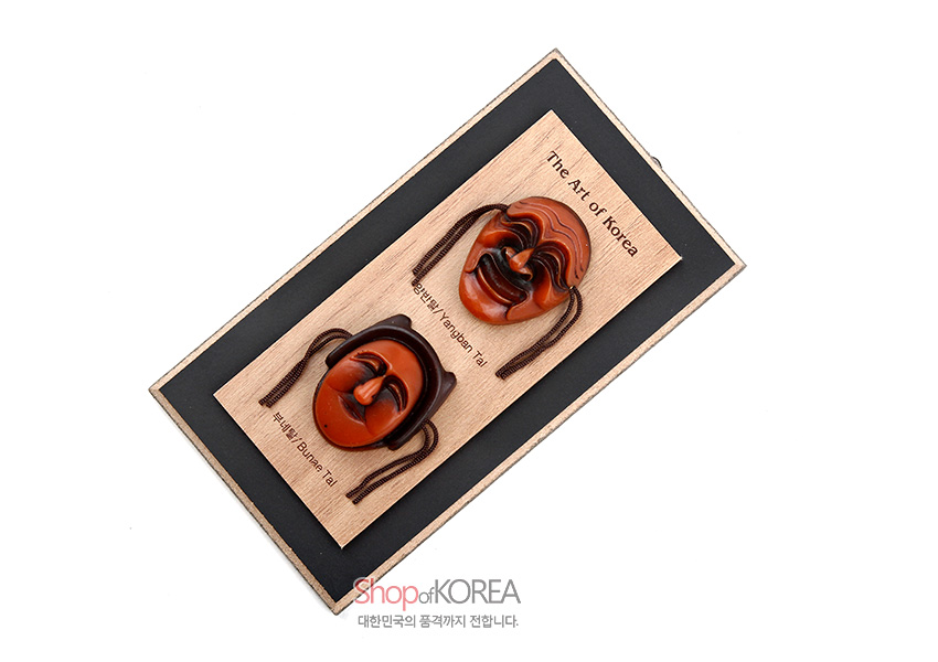 [텍스트: The Art of Korea, Tal, Hahoe-yangban Tal, Hahoe Bune Tal, Shop of KOREA, 대한민국의 품격까지 전합니다.] 나뭇결이 드러난 원목 판 위에 갈색과 주황색 톤의 양반탈과 부네탈 입체 조각을 배치한 세로형 미니 액자 디자인