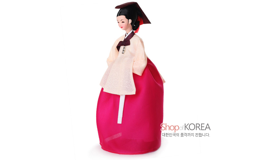 [텍스트: Shop of KOREA 대한민국의 품격까지 전합니다.] 비단 느낌의 아이보리 저고리와 양단 짜임이 은은한 무늬의 선홍색 치마, 자주색 고름과 쓰개로 장식된 전통 의녀 한복 인형 모습