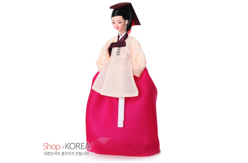 [텍스트: Shop of KOREA 대한민국의 품격까지 전합니다.] 비단 느낌 연분홍 저고리와 자주색 고름, 붉은색 치마가 조화된 의녀 한복 인형 모습