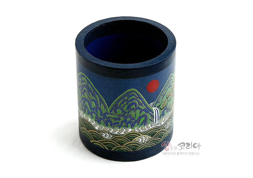 [텍스트: 샵오브코리아 대한민국의 품격까지 전합니다.] 짙은 남색 원통형 펜꽂이에 녹색과 금색 위주의 일월오봉도 산수문과 붉은 해, 파도무늬를 채색한 디자인