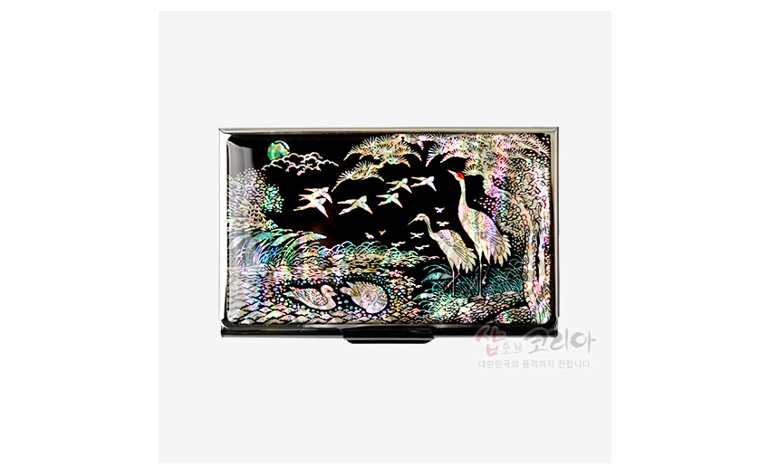 [텍스트: 샵오브코리아 대한민국의 품격까지 전합니다.] 흑색 바탕 금속 명함집 위 자개 상감 기법으로 송학과 소나무, 연못과 물가 풍경을 오색으로 표현한 디자인