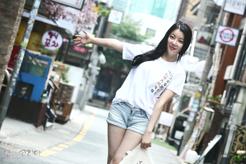 [텍스트: 샵오브코리아] 흰색 면 티셔츠에 다채로운 색상의 한글 자음을 세로 배열한 3D 입체발포 프린트 디자인 모습