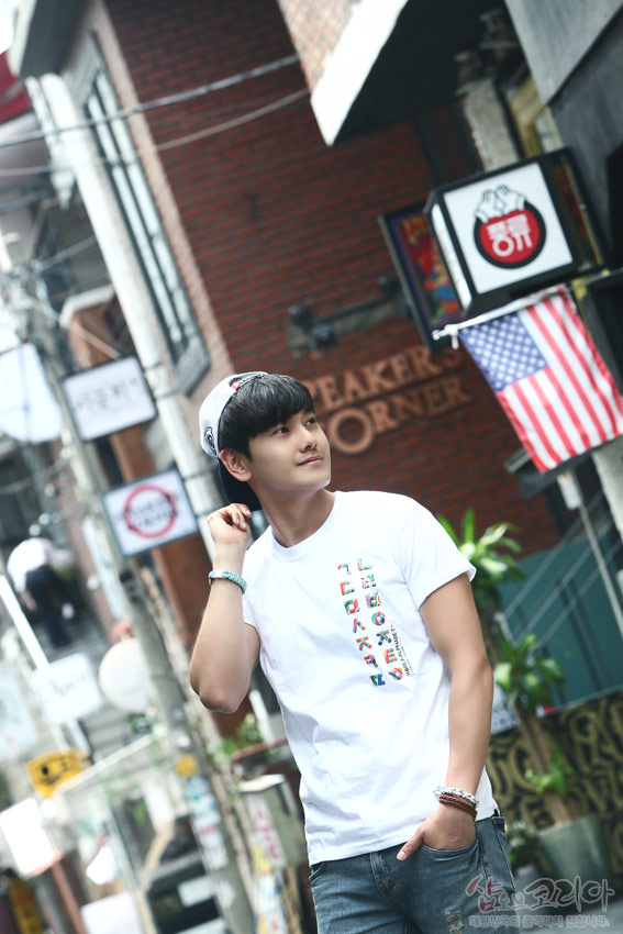 [텍스트: SPEAKER'S CORNER] 흰색 면 티셔츠에 다채로운 색상 한글 자음 세로 배열 입체발포 프린트 장식 모습