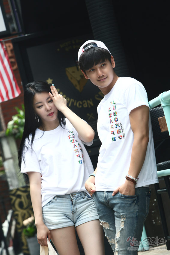 [텍스트: HANGUL CONSONANT, SHOF KOREA] 흰색 면 티셔츠 위 세로 배열 다채로운 한글 자음 입체발포 프린트 장식 모습