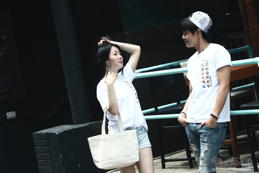 [텍스트: 샵오브코리아] 흰색 면 티셔츠 위 세로 배열된 다채로운 색상의 한글 자음 입체발포 프린트 장식 모습