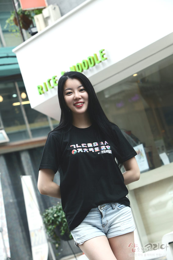 [텍스트: RICE & NOODLE] 검정색 면 티셔츠 위 가로 배열 한글 자음 3D 입체발포 프린트, 알록달록한 색상 대비가 돋보이는 캐주얼 연출