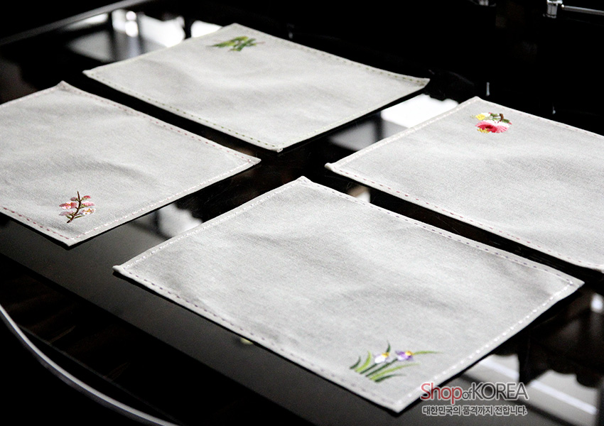 [텍스트: ShopofKOREA 대한민국의 품격까지 전합니다] 옅은 회색 모시 원단에 사군자 꽃 자수와 가장자리 스티치가 수놓인 사각 식탁보 4인 세트 이미지