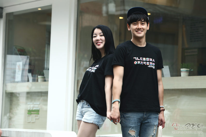 [텍스트: ㄱㄴㄷㄹㅁㅂㅅ ㅇㅈㅊㅋㅌㅍㅎ] 흑색 면 소재에 한글 자음 가로 배열 3D 입체발포 프린트가 들어간 캐주얼 반팔 티셔츠 연출 이미지