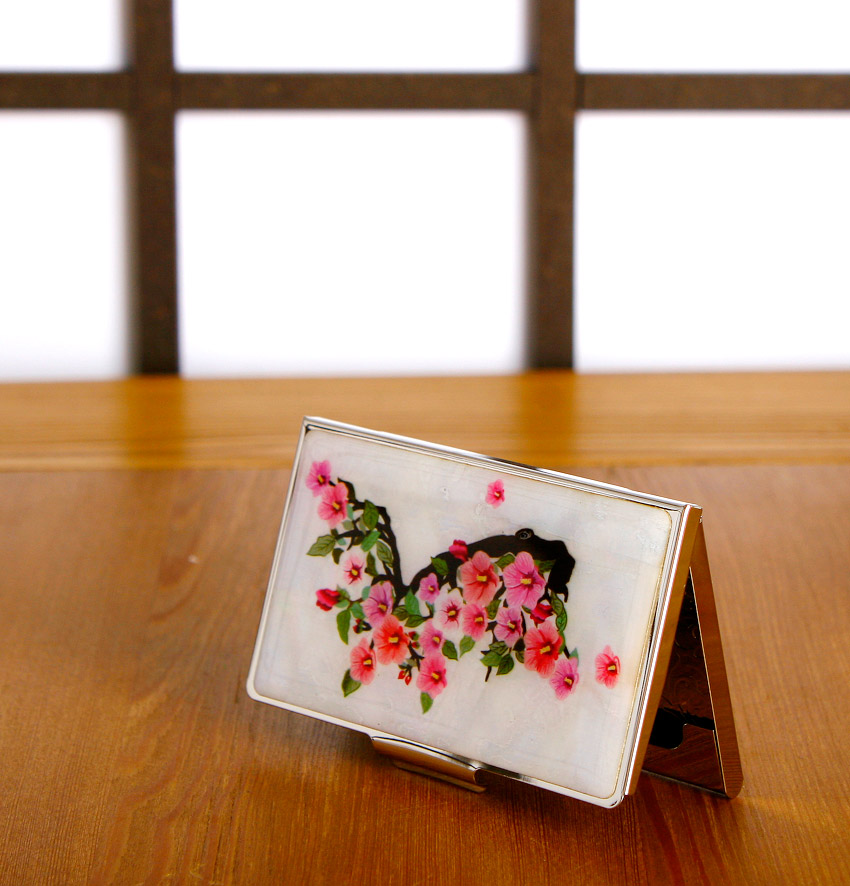 자개 느낌의 흰 바탕 위에 한반도 실루엣을 검은색으로 배치하고, 분홍색 무궁화와 초록 잎을 섬세한 채색 기법으로 장식한 금속 명함집 이미지 설명