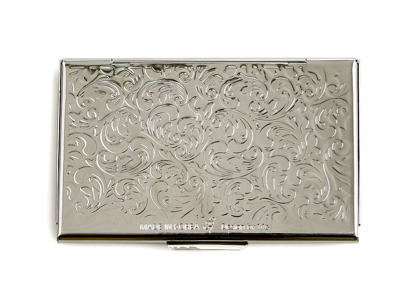 [텍스트: MADE IN KOREA Design by Mr.] 금속 재질의 광택 있는 표면에 섬세한 식물문양을 음각으로 새긴 직사각형 명함집 디자인
