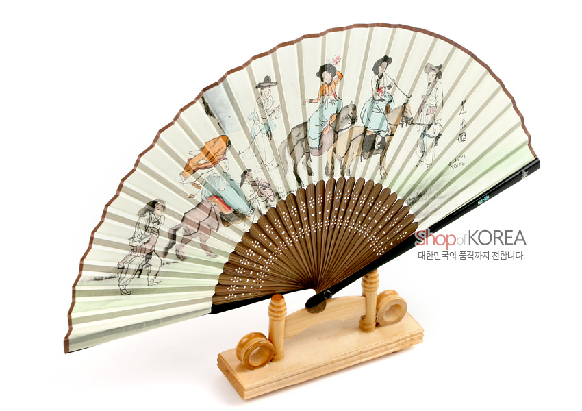 [텍스트: Shop of KOREA, 대한민국의 품격까지 전합니다.] 한지에 담채로 표현된 봄나들이 인물과 기마 행렬 민속도, 갈색 나무살대 천공 장식과 은은한 베이지·연녹색 그라데이션이 어우러진 합죽선 형태의 실크풍 접부채 이미지 설명