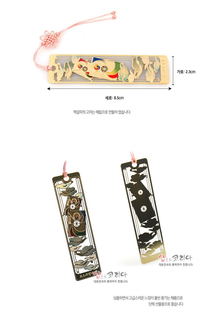 [텍스트: 세로: 8.5cm / 가로: 2.3cm / 책갈피의 고리는 매듭으로 만들어 졌습니다 / 회오리방패연] 금장 금속 재질 위 오방색 회오리 방패연과 구름 문양 상감, 분홍 매듭 끈 장식 직사각 책갈피 디자인