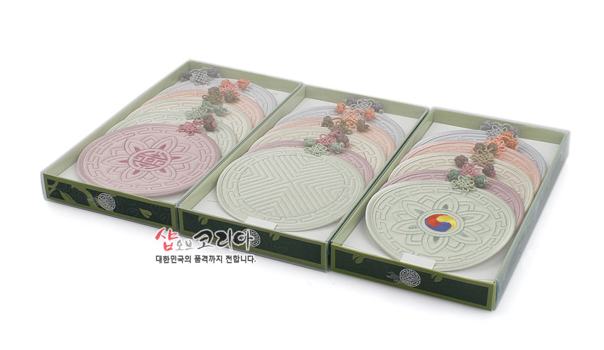 [텍스트: 샵오브코리아 대한민국의 품격까지 전합니다.] 파스텔톤 누비 원형 컵받침 세트, 연꽃·수복문·태극 문양과 꽃 매듭 장식이 조화를 이룬 패브릭 공예품