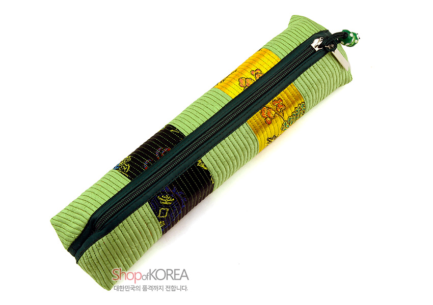 [텍스트: Shop of KOREA 대한민국의 품격까지 전합니다.] 연두색 누비 원단에 노랑·검정 실크 꽃문양 패치를 더한 지퍼 여밈 직사각 필통 디자인