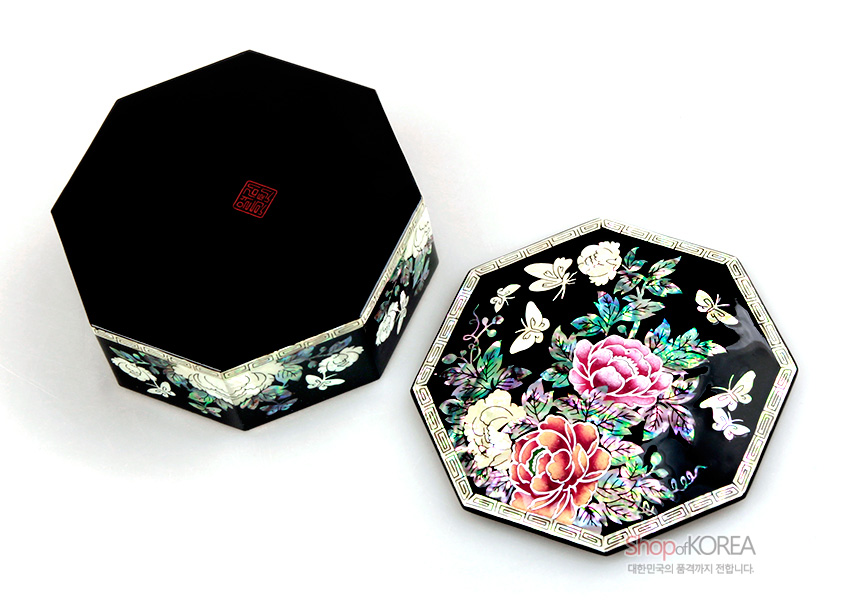 [텍스트: shopofKOREA 대한민국의 품격까지 전합니다.] 흑색 옻칠 바탕에 자개 상감 기법으로 형상화한 목단 꽃과 나비 문양, 팔각 형태와 은은한 오색 광택이 돋보이는 보석함 디자인
