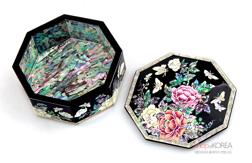 [텍스트: shop of KOREA 대한민국의 품격까지 전합니다.] 흑색 옻칠 바탕에 자개 상감 기법으로 목단꽃과 나비 문양을 섬세하게 장식한 팔각 다용도함 내부 전면 자개 마감 구성