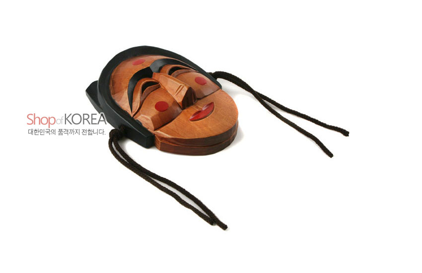 [텍스트: Shop of KOREA 대한민국의 품격까지 전합니다.] 갈색 원목 조각에 흑색 머리장식과 끈, 붉은 볼점과 입술 채색이 어우러진 전통 하회 부네탈 형태의 목각 마스크 이미지 설명