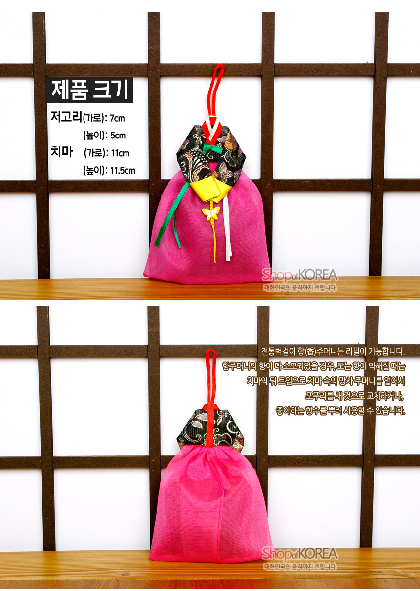 [텍스트: 제품 크기 저고리(가로): 7cm (높이): 5cm 치마 (가로): 11cm (높이): 11.5cm 전통벽걸이 향(香)주머니는 리필이 가능합니다. 향주머니의 향이 다소 묽어졌을 경우, 또는 향이 약해졌을 때는 치마의 뒤 트임으로 치마 속의 망사주머니를 열어서 포푸리로 채 것으로 교체하거나 좋아하는 향수를 뿌려 사용하실 수 있습니다. Shop of KOREA 대한민국의 공예가치 전달합니다.] 분홍 비단 치마와 흑색 꽃문양 양단 저고리 장식, 색동 끈과 나비 매듭이 더해진 한복 형태 전통 벽걸이 향주머니 모습