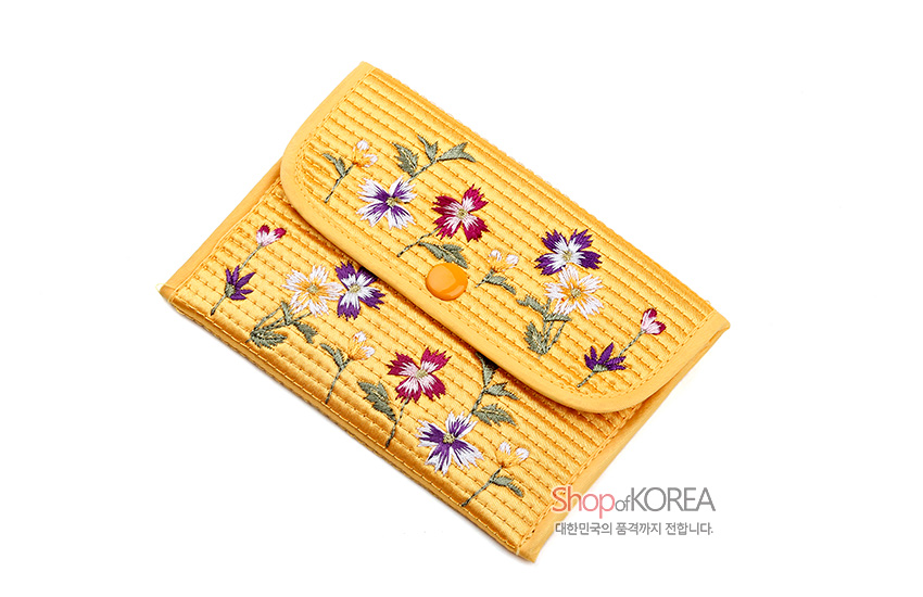[텍스트: ShopofKOREA 대한민국의 품격까지 전합니다.] 노란색 누비 천에 보라·빨강·흰색 꽃과 초록 줄기를 자수한 사각 똑딱이 동전지갑 디자인