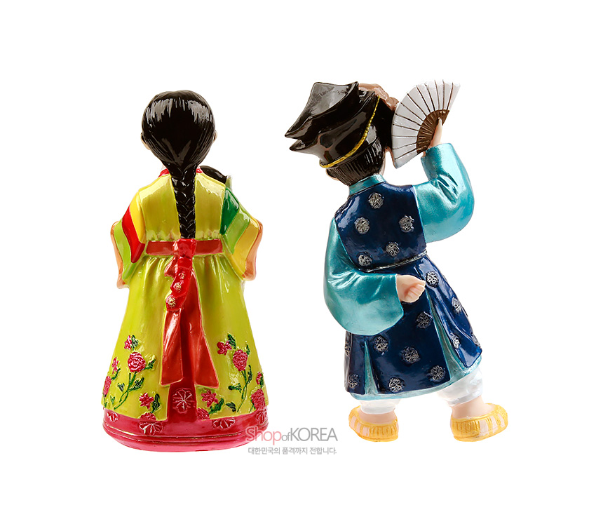 [텍스트: ShopKOREA 대한민국의 품격까지 전합니다.] 채색 도자 재질의 남녀 탈춤 인형, 청색과 연두색 한복 위 화려한 꽃문양과 문양포, 손 부채와 땋은 머리 장식을 강조한 디자인